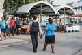 Couple holding hands walking at a street market in Bridgetown, Barbados.